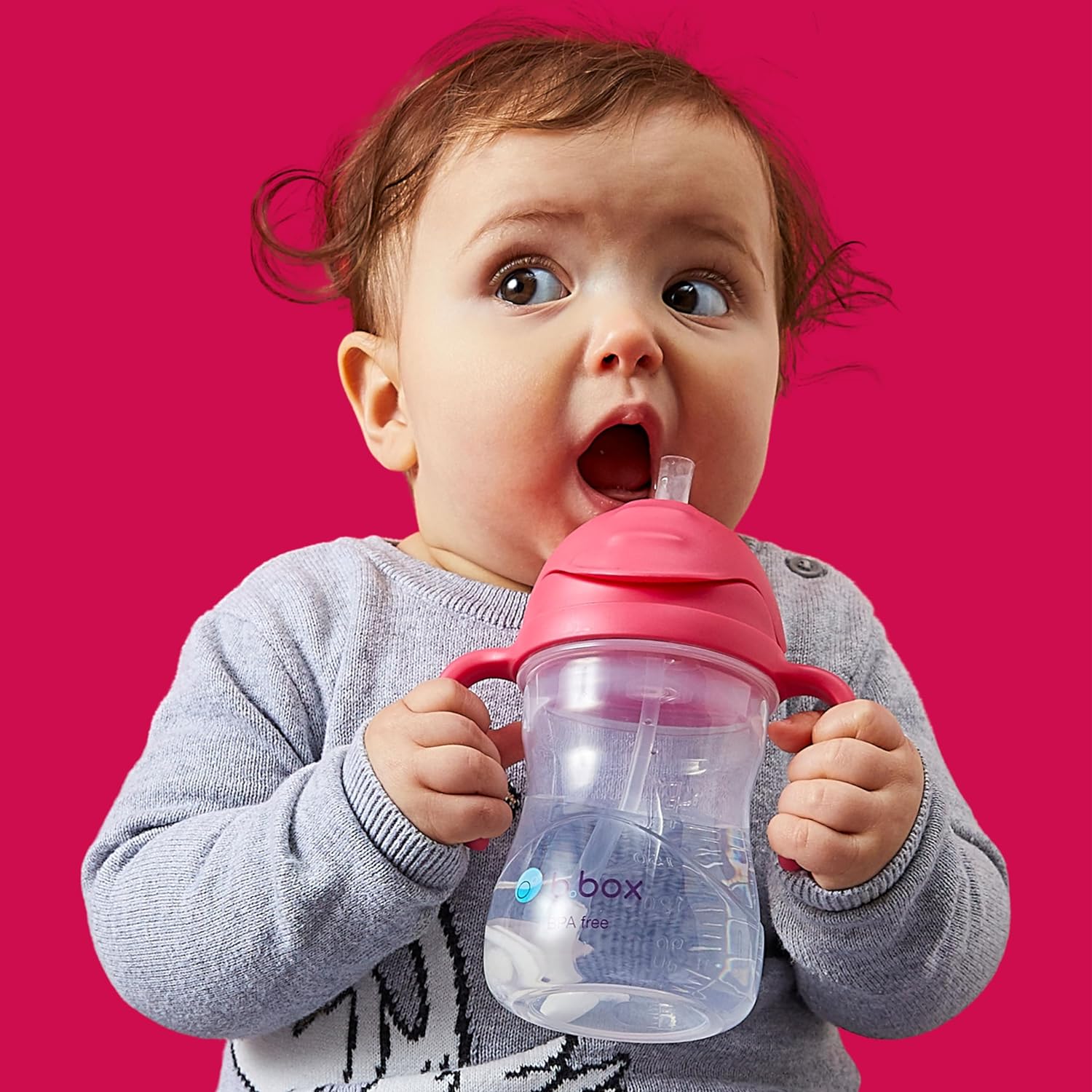 A baby drinking from a sippy cupDescription automatically generated